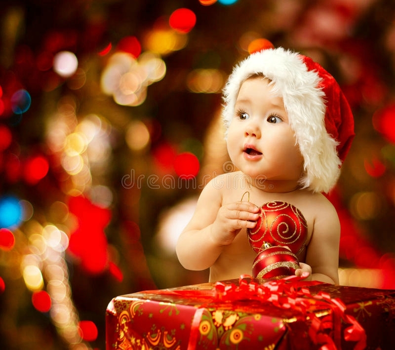 christmas-baby-santa-hat-near-red-present-gift-box-holding-ball-35087259