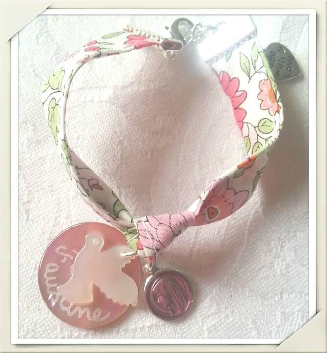 Bracelet sur ruban d'Anjo rose composé d'une médaille en nacre rose, une colombe en nacre et une mini médaille émaillée ronde rose