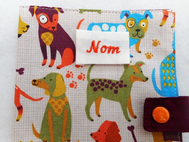 Protège carnet chiens colorés fond carreaux zoom