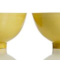 A fine pair of <b>Imperial</b> <b>yellow</b>-glazed porcelain bowls, underglaze blue Kangxi six-character marks and period