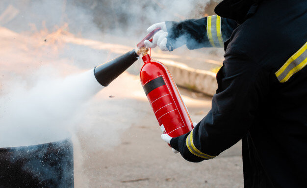 Un agent vérificateur d’appareils extincteurs assure que vos outils anti-incendie fonctionnent © image libre de droits Google