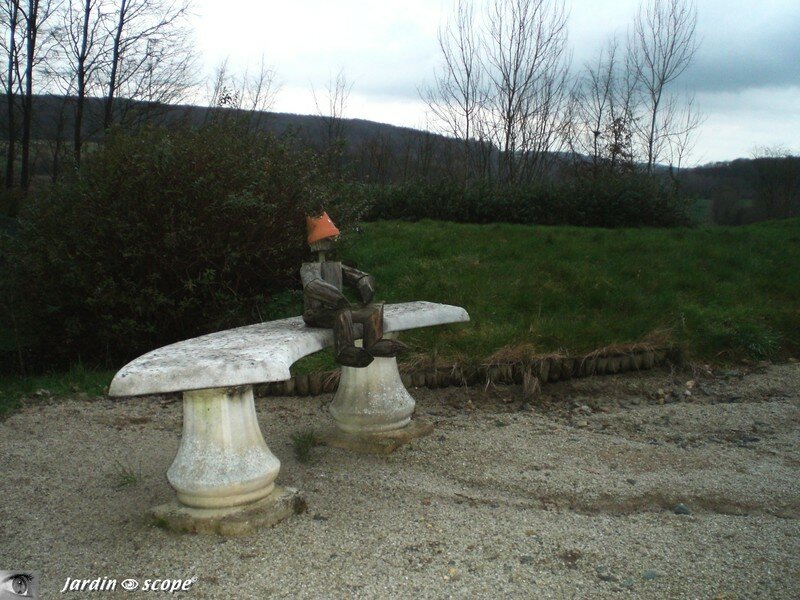 Bonhomme de bois assis sur un banc de pierre