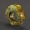 A celadon and brown jade '<b>dragon</b> <b>head</b>' ring ornament, Neolithic period, Liangzhu culture